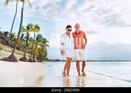 Coppia innamorata mentre cammina su una spiaggia sabbiosa esotica. Hanno una passeggiata serale sul mare di Trou-aux-Biches sull'isola di Mauritius. Persone relati Foto Stock