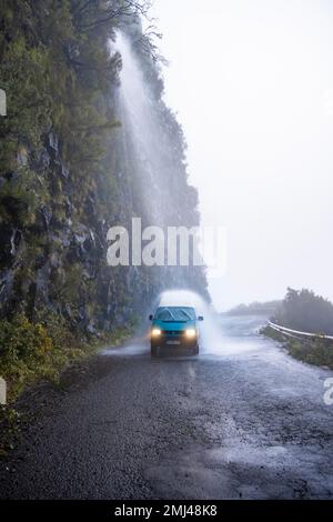 Cascata dos Anjos, autobus VW conduce attraverso una cascata sulla strada, Madeira, Portogallo Foto Stock