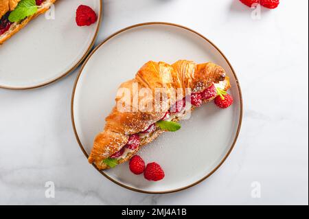 Croissant con lamponi freschi Foto Stock