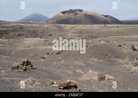 Vecchio cono vulcanico circondato da lava a Tinajo, Lanzarote Foto Stock