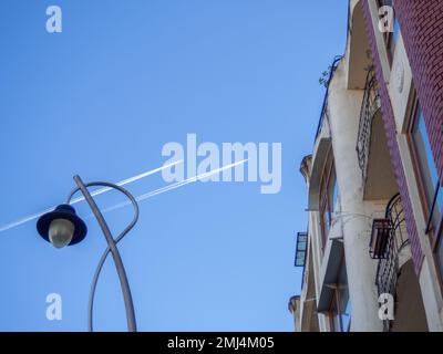 Tracce dal percorso del velivolo sullo sfondo dell'edificio. Un sentiero nel cielo da un aereo. Ambiente urbano. Due aerei stanno volando Foto Stock