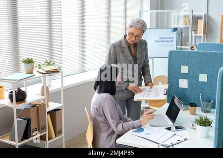 Ritratto del dirigente aziendale senior che istruisce i dipendenti in ufficio, spazio copia Foto Stock