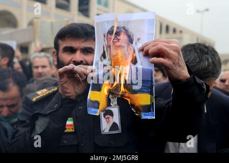 Teheran, Iran. 27th Jan, 2023. Gli iraniani bruciano una foto del presidente francese Emmanuel Macron durante una protesta contro l'incendio di un Corano a Stoccolma. Rasmus Paludan, politico di estrema destra svedese-danese, ha dato fuoco a una copia del libro sacro musulmano di fronte all'ambasciata turca nella capitale svedese. Molti paesi musulmani hanno detto di essere indignati dalla bruciatura del Corano, che il primo ministro svedese Ulf Kristersson ha condannato come 'fortemente irrispettoso' (Credit Image: © Rouzbeh Fouladi/ZUMA Press Wire) SOLO PER USO EDITORIALE! Non per USO commerciale! Foto Stock