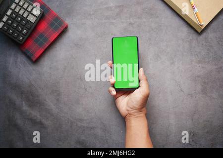 vista dall'alto della mano dell'uomo utilizzando lo smartphone in ufficio scrivania Foto Stock
