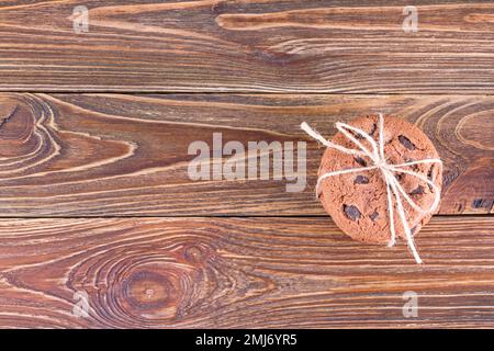 Vista dall'alto dei biscotti alla farina d'avena con cioccolato su un tavolo di legno con spazio per il testo, piatto. Biscotti fatti in casa su un vecchio tavolo di legno Foto Stock