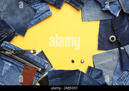 Cornice in jeans tagliati su sfondo giallo. Spazio per il testo Foto Stock