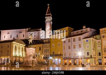 Piran, Slovenia - 14 ottobre 2022: Vista sulla Piazza Tartini a Piran con architettura colorata e la Basilica di San La torre della chiesa parrocchiale di George. Foto Stock