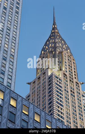 La corona iconica del Chrysler Building, incorniciata dal Socony-Mobil Building rivestito in acciaio inossidabile, cambia da grigio a oro alla luce dell'alba. Foto Stock