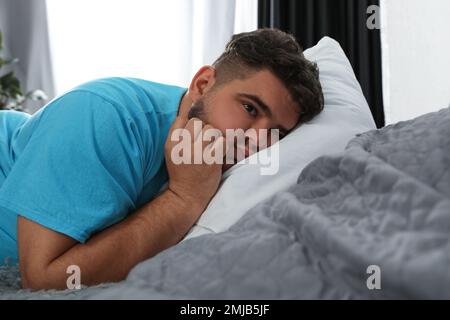 Uomo sovrappeso che soffre di depressione a letto Foto Stock