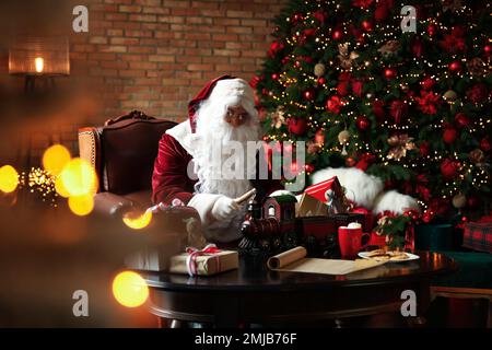 Babbo Natale fare nuovo giocattolo per Natale in officina Foto Stock