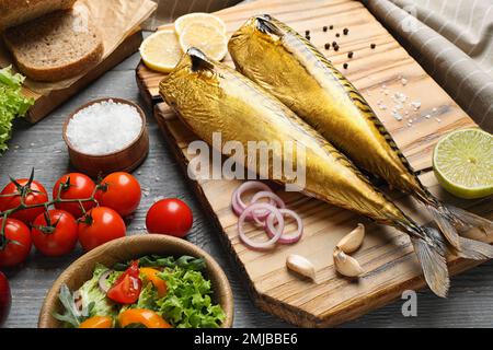 Gustoso pesce affumicato servito su un tavolo di legno Foto Stock