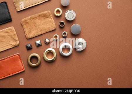 Composizione a posa piatta con accessori per capi di abbigliamento per jeans su sfondo marrone Foto Stock