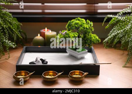 Bel giardino zen in miniatura, candele e lampade ad olio sul tavolo Foto  stock - Alamy