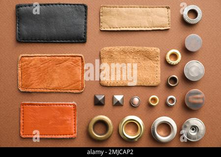 Composizione a posa piatta con accessori per capi di abbigliamento per jeans su sfondo marrone Foto Stock