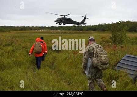 Un equipaggio di elicotteri della Guardia Nazionale dell'Alaska Army raccoglie i membri della Guardia Costiera dal settore Anchorage e un reclutatore ANG da una comunità remota vicino a Bethel Alaska, il 26 agosto 2022. Le squadre composte da sei ispettori marini della Guardia Costiera hanno visitato un totale di 20 comunità e ispezionato circa 50 impianti di stoccaggio di combustibile all'ingrosso dal 22 al 30 agosto, con il trasporto da Bethel a comunità più remote fornito da tre membri della Guardia Nazionale dell'Alaska Armata e tre piloti di pattuglia dell'aria civile. Foto Stock