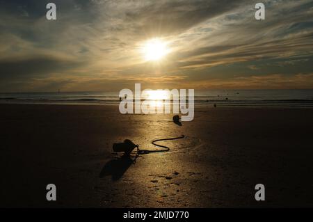 La gente che gode il tramonto bello sulla spiaggia di Trouville in Normandia Francia in Una bella giornata estiva di sole con Alcune nuvole nel cielo Foto Stock