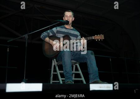 220827-N-VJ326-1326 SOUTH CHINA SEA (27 agosto 2022) – Master-at-Arms 2nd Class Kyle Chasse, da Liverpool, New York, canta e suona la chitarra durante un concorso di talenti a bordo di un carrier d'assalto anfibio USS Tripoli (LHA 7), 27 agosto 2022. Tripoli opera nell'area delle operazioni della flotta 7th degli Stati Uniti per migliorare l'interoperabilità con alleati e partner e fungere da pronta forza di risposta per difendere la pace e mantenere la stabilità nella regione dell'Indo-Pacifico. Foto Stock