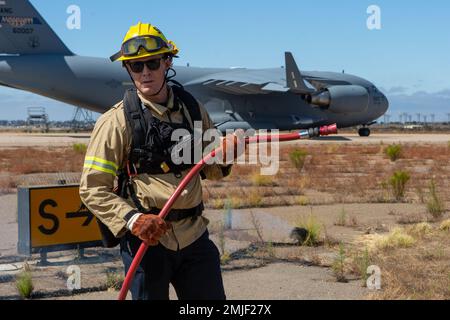 Un pompiere di San Diego Fire Rescue si pone di fronte all'evento di bruciatura prescritto a MCAS Miramar, San Diego, California, 27 agosto 2022. La combustione prescritta è stata condotta come misura preventiva per eliminare le sostanze infiammabili o la sottobosco che potrebbero diffondere il fuoco durante il MCAS Miramar Air Show 2022. Foto Stock