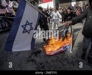 Gaza, Palestina. 27th Jan, 2023. I sostenitori palestinesi del movimento della Jihad islamica bruciano le bandiere di Israele e America durante la manifestazione nel campo di Jabalia nella striscia di Gaza settentrionale, a sostegno del campo di Jenin in Cisgiordania, un giorno dopo che un israeliano è stato ucciso. I militari israeliani e palestinesi nella striscia di Gaza si scambiarono un razzo, sollevando il timore di un'altra escalation dopo una delle incursioni più pesanti dell'esercito nella Cisgiordania occupata negli ultimi anni. Credit: SOPA Images Limited/Alamy Live News Foto Stock