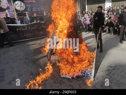 Gaza, Palestina. 27th Jan, 2023. I sostenitori palestinesi del movimento della Jihad islamica bruciano le bandiere di Israele e America durante la manifestazione nel campo di Jabalia nella striscia di Gaza settentrionale, a sostegno del campo di Jenin in Cisgiordania, un giorno dopo che un israeliano è stato ucciso. I militari israeliani e palestinesi nella striscia di Gaza si scambiarono un razzo, sollevando il timore di un'altra escalation dopo una delle incursioni più pesanti dell'esercito nella Cisgiordania occupata negli ultimi anni. Credit: SOPA Images Limited/Alamy Live News Foto Stock