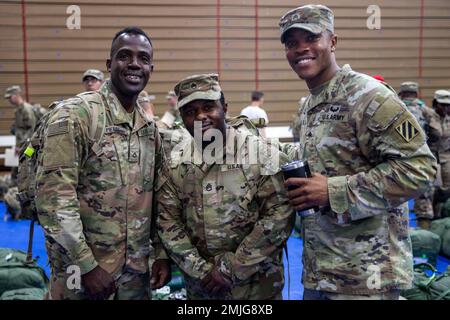 STATI UNITI Ralph Pierre, staff Sgt. Brandon Mings e Sgt. Kurtavious Bell, assegnati al 1st Armored Brigade Combat Team, 3rd° Divisione fanteria, si riuniscono durante una cerimonia di ridistribuzione a Fort Stewart, Georgia, 29 agosto 2022. I 1st soldati dell'ABCT si sono schierati in Germania per assicurare gli alleati e dissuadere l'aggressione russa, sostenendo al contempo una serie di altri requisiti nella zona. Foto Stock