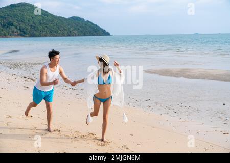 Felice coppia giovane correre sulla spiaggia Foto Stock
