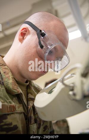 Senior Airman Hayden Lyon, un 18th manutenzione componenti Squadron avionics Intermediate shop journeyman, utilizza uno strumento di ingrandimento per migliorare la grafica durante la saldatura di un componente per l'assemblaggio di schede a circuito nell'AIS presso la base aerea di Kadena, Giappone, 29 agosto 2022. L'AIS si occupa di molti tipi di problemi elettrici, pertanto la presenza di una stazione di saldatura interna consente loro di completare le riparazioni in modo efficiente. Foto Stock