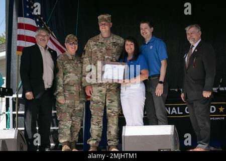 Il Minnesota National Guard Soldier, Major Adam Feia, si trova con il suo supervisore, Kellie, per ricevere il riconoscimento per conto del loro datore di lavoro, Graco, 30 agosto 2022, a Falcon Heights. Durante il Minnesota state Fair's Military Appreciation Day, Employer Support of the Guard and Reserve ha riconosciuto e onorato 23 datori di lavoro di famiglie militari. (Foto della Guardia Nazionale del Minnesota del personale Sgt. Mahsima Alkamooneh) Foto Stock
