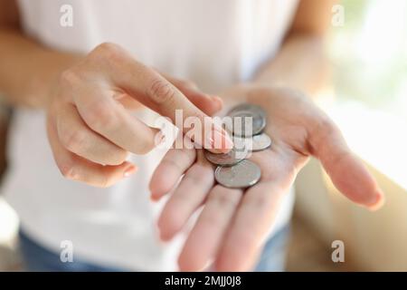 Donna che conta piccole monete nelle sue mani primo piano. Foto Stock