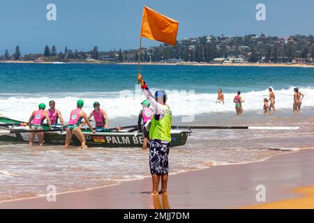 Australian 2023 Surfboat Racing carnevale a Narrabeen Beach, squadre maschili e femminili, maresciallo gara si prepara per l'inizio di calore, Sydney, NSW, Australia Foto Stock