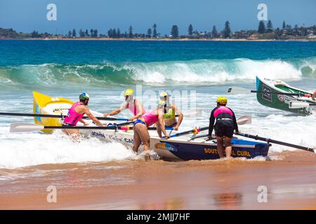 Sydney Northern Beaches Surfboat carnevale a North Narrabeen Beach, gli equipaggi maschili si preparano per l'inizio della corsa, Sydney, NSW, Australia Foto Stock