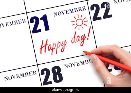 21st° giorno di novembre. Scrivere a mano il testo HAPPY DAY e disegnare il sole sulla data del calendario 21 novembre. Salvare la data. Vacanza. Motivazione. Autunno Foto Stock