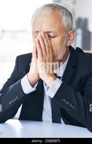 Le cose non stanno andando come aveva progettato. un uomo d'affari maturo che guarda stressato fuori sul lavoro. Foto Stock