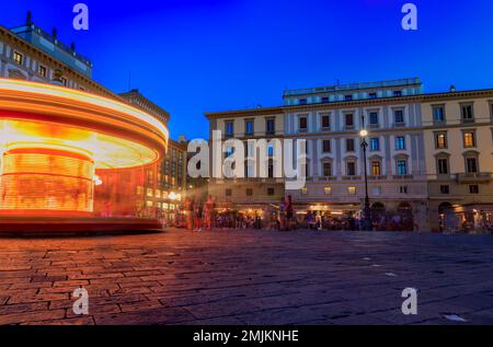 Luci dell'antica giostra illuminata rotante in Piazza della Repubblica a Firenze al tramonto Foto Stock