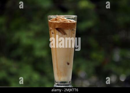Dalgona Ice Coffee è una bevanda prodotta miscelando parti uguali di caffè istantaneo, zucchero e acqua calda. La miscela viene quindi montata fino a diventare cremosa e. Foto Stock