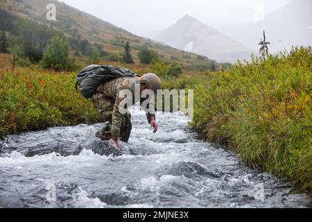 NEGLI STATI UNITI Il paracadutista dell'esercito, assegnato alla Joint Communications Support Element, MacDill Air Force base, si porta al punto di raduno dopo le operazioni in volo a Geronimo Drop zone, Joint base Elmendorf-Richardson, Alaska, 31 agosto 2022. Guerra speciale dell'aeronautica e clima di combattimento Airmen e paracadutisti dell'esercito, supportati dall'equipaggio della Guardia Nazionale dell'Alaska del comando di truppe dell'aviazione del 207th, hanno condotto l'addestramento per dimostrare le abilità aerotrasportate e di missione-preparazione in condizioni austere. Foto Stock