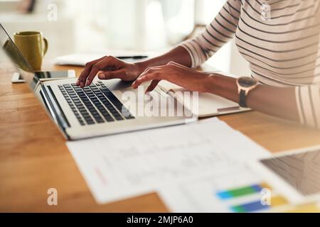 Avvicinandosi al successo. una donna irriconoscibile che lavora sul suo notebook a casa. Foto Stock