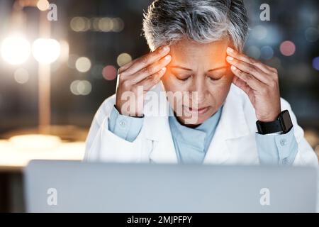 Notte, stress e mal di testa con il medico al computer portatile per la revisione medica, stress e scadenza. Burnout, responsabilità e salute mentale con la donna anziana Foto Stock