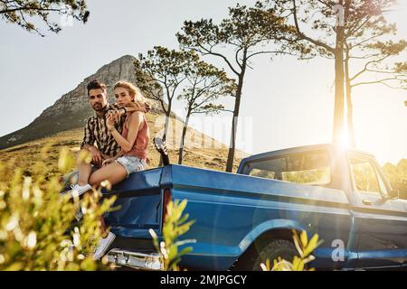 Viaggiare con il mio Soulmate al mio fianco. una coppia affettuosa che si tira per ammirare il paesaggio durante un viaggio su strada. Foto Stock