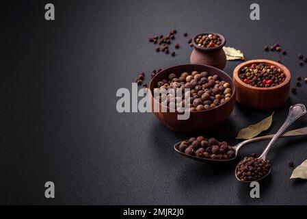 Colore marrone speziato non macinato in un piattino di legno su fondo di cemento scuro Foto Stock