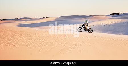 Deserto, natura e atleta in moto per l'esercizio fisico, fitness o allenamento di abilità in natura. Sport estremi, azione e atleta maschile su una bicicletta Foto Stock