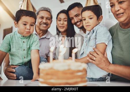 Compleanno, famiglia e bambini con genitori e nonni in cucina per dolci, celebrazioni e legami. Festa e bambini con madre e padre Foto Stock