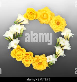 Corona di fiori di rosa e di freesia. Struttura rotonda naturale con motivi floreali creativi su sfondo grigio sfumato. Foto Stock