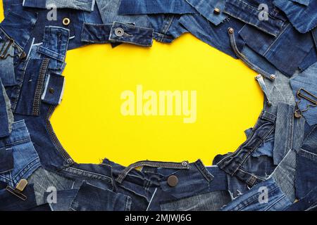 Cornice in jeans tagliati su sfondo giallo. Spazio per il testo Foto Stock