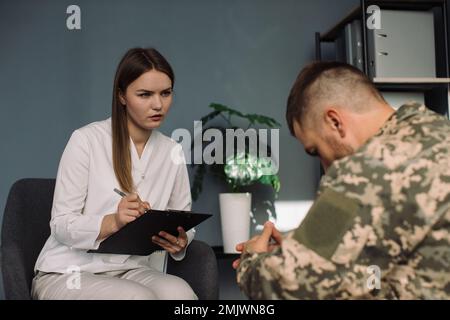 Psicoterapeuta che lavora con ufficiale militare in carica Foto Stock