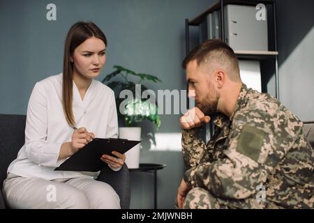 Psicoterapeuta che lavora con ufficiale militare in carica Foto Stock