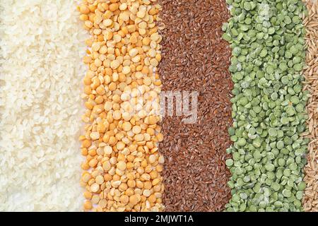 Grani e cereali diversi come sfondo, vista dall'alto Foto Stock