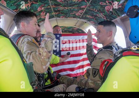 Staff Sgt. Saul Rivera (a destra), un ufficiale operativo non commissionato presso il Midwest Joint Regional Correctional Facility, recita il giuramento di arruolamento in un aereo. Rivera riarruolato nell'esercito e poi celebrato con il paracadutismo. Il capitano Hallie Freeman (a sinistra) ha condotto il giuramento. Foto Stock