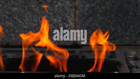 La fiamma eterna brucia sullo sfondo di pietre scure al memoriale della seconda guerra mondiale dei soldati sovietici in Russia Foto Stock