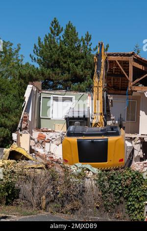 digger demolendo vecchia casa per la ricostruzione nuova casa Foto Stock